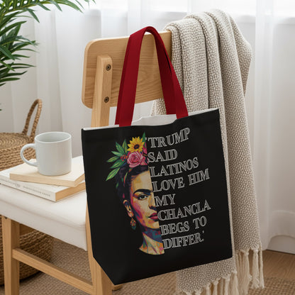 Frida Kahlo portrait on black tote bag with floral headpiece and text.