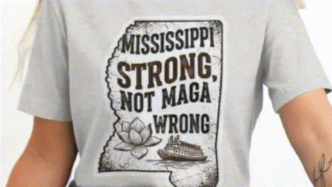 A person wearing a grey t-shirt with a graphic design that says "Mississippi Strong, Not Maga Wrong" and features a boat.