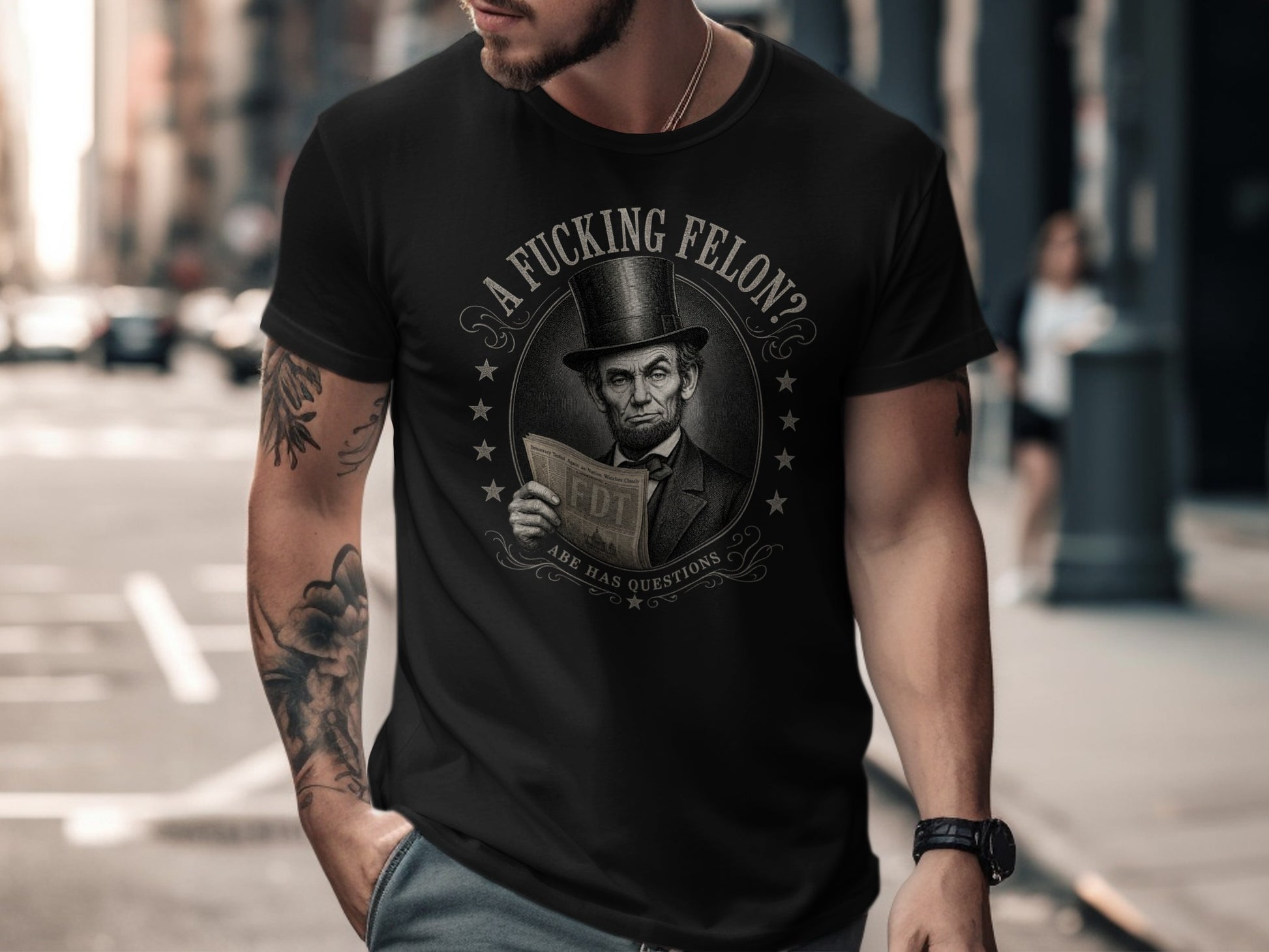 Black t-shirt with Abraham Lincoln holding a newspaper asking "A Fucking Felon?"
