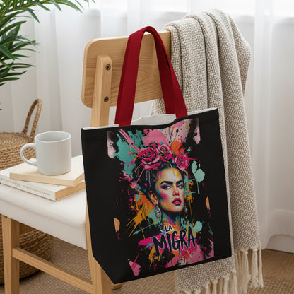 Black tote bag with colorful Frida Kahlo-inspired artwork and "LA MIGRA" text.