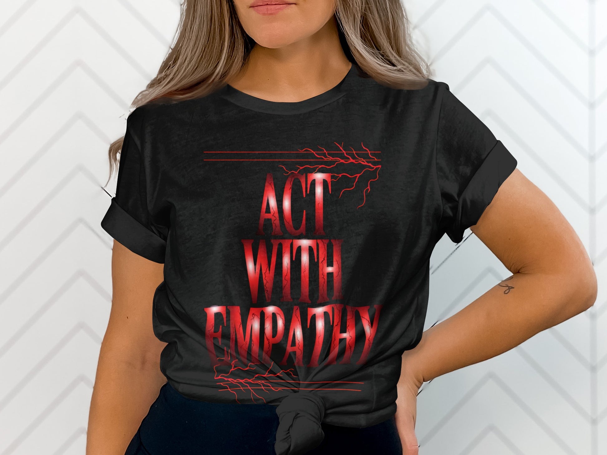 Black t-shirt with red text "ACT WITH EMPATHY" and lightning graphics.