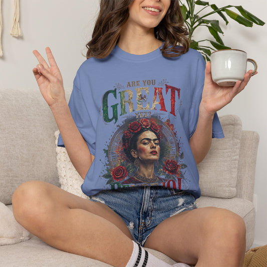 Woman in blue t-shirt with Frida Kahlo graphic, holding a mug.