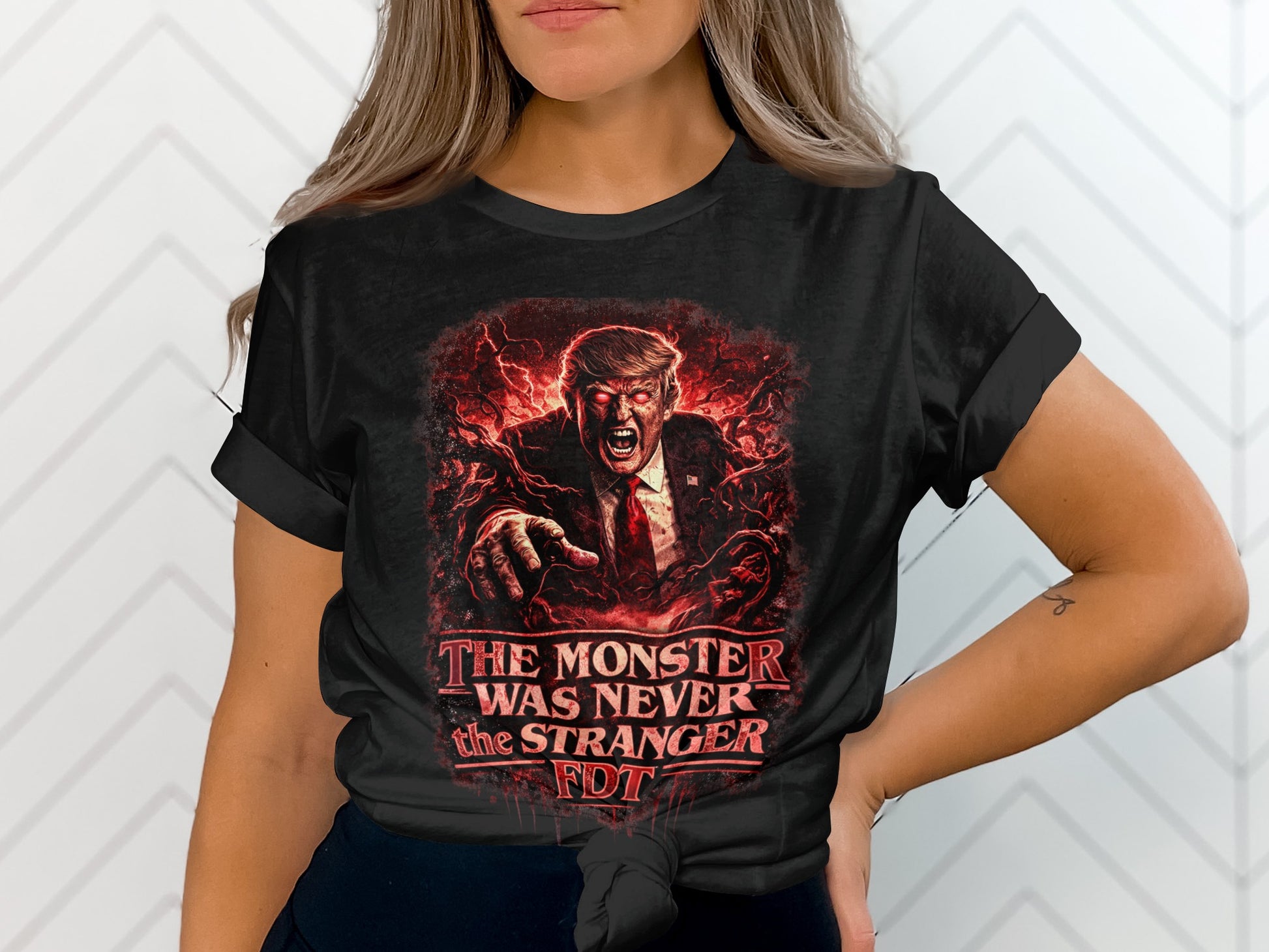 Black t-shirt with "The Monster Was Never Stranger" text and Trump's face.
