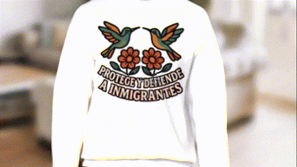 A person wearing a white sweatshirt with a graphic design on the back.