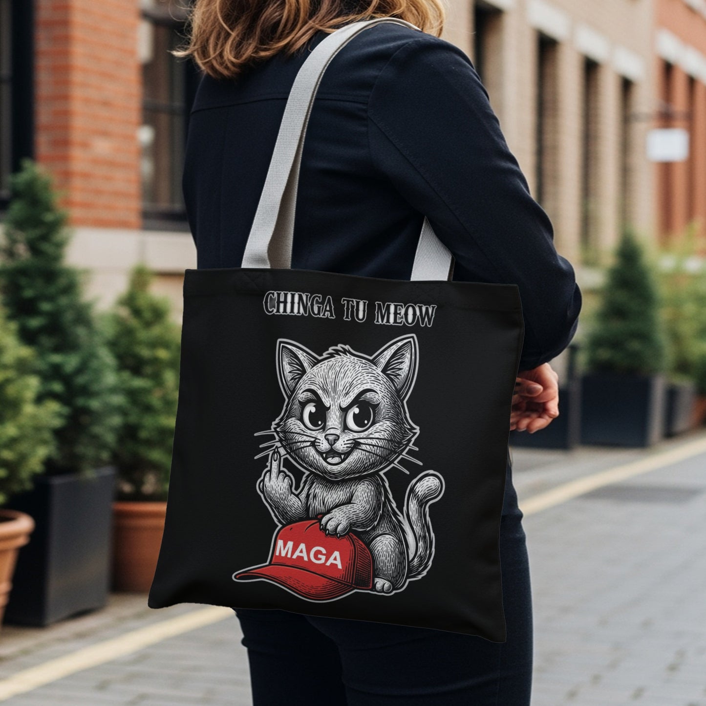 Black tote bag with a cat flipping off a MAGA hat, text reads "CHINGA TU MEOW".