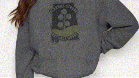 A person wearing a grey sweatshirt with a graphic design on the back.