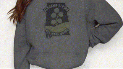 A person wearing a grey sweatshirt with a graphic design on the back.