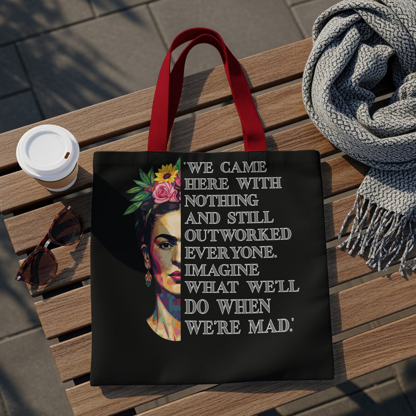 Black tote bag with Frida Kahlo-inspired portrait and empowering quote.