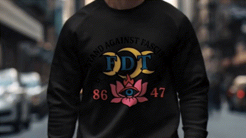 A person wearing a black sweatshirt with a colorful graphic design on it, standing in a city street.