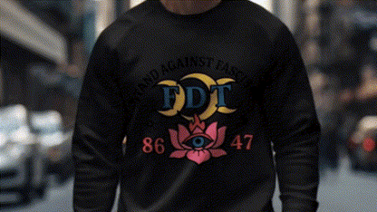 A person wearing a black sweatshirt with a colorful graphic design on it, standing in a city street.