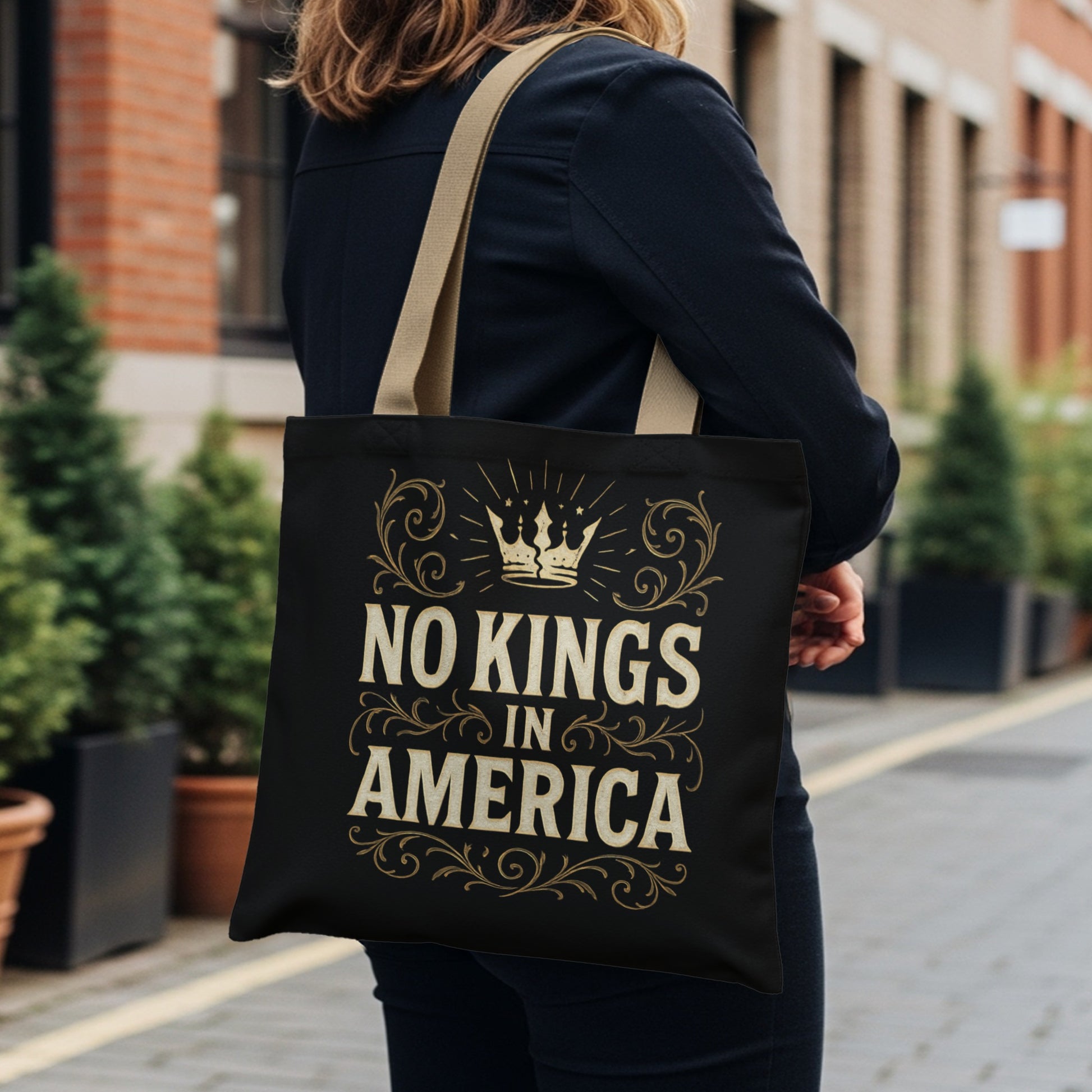 Black tote bag with "No Kings in America" text and crown design.