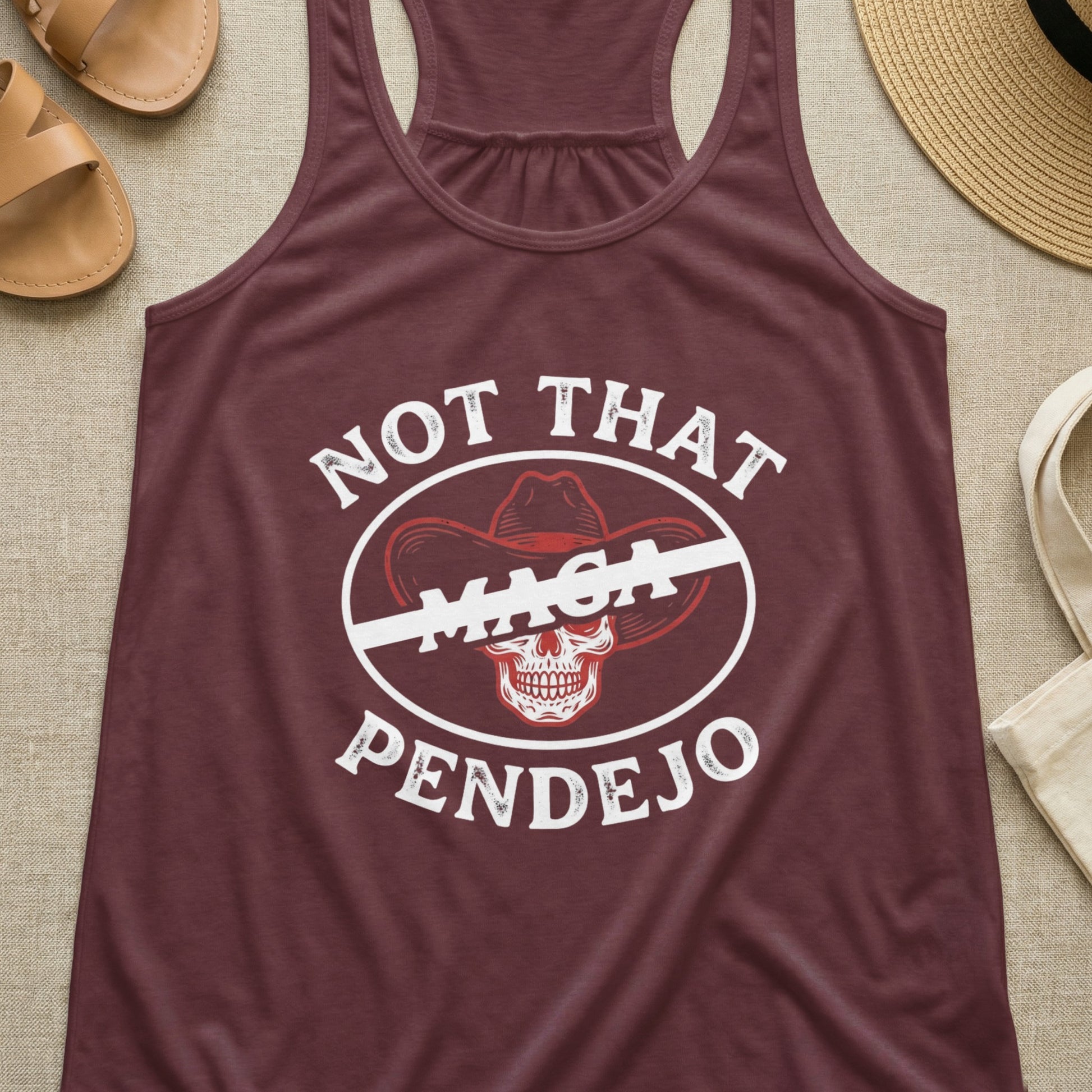 Maroon tank top with "Not That MAGA Pendejo" text and crossed-out cowboy hat graphic.