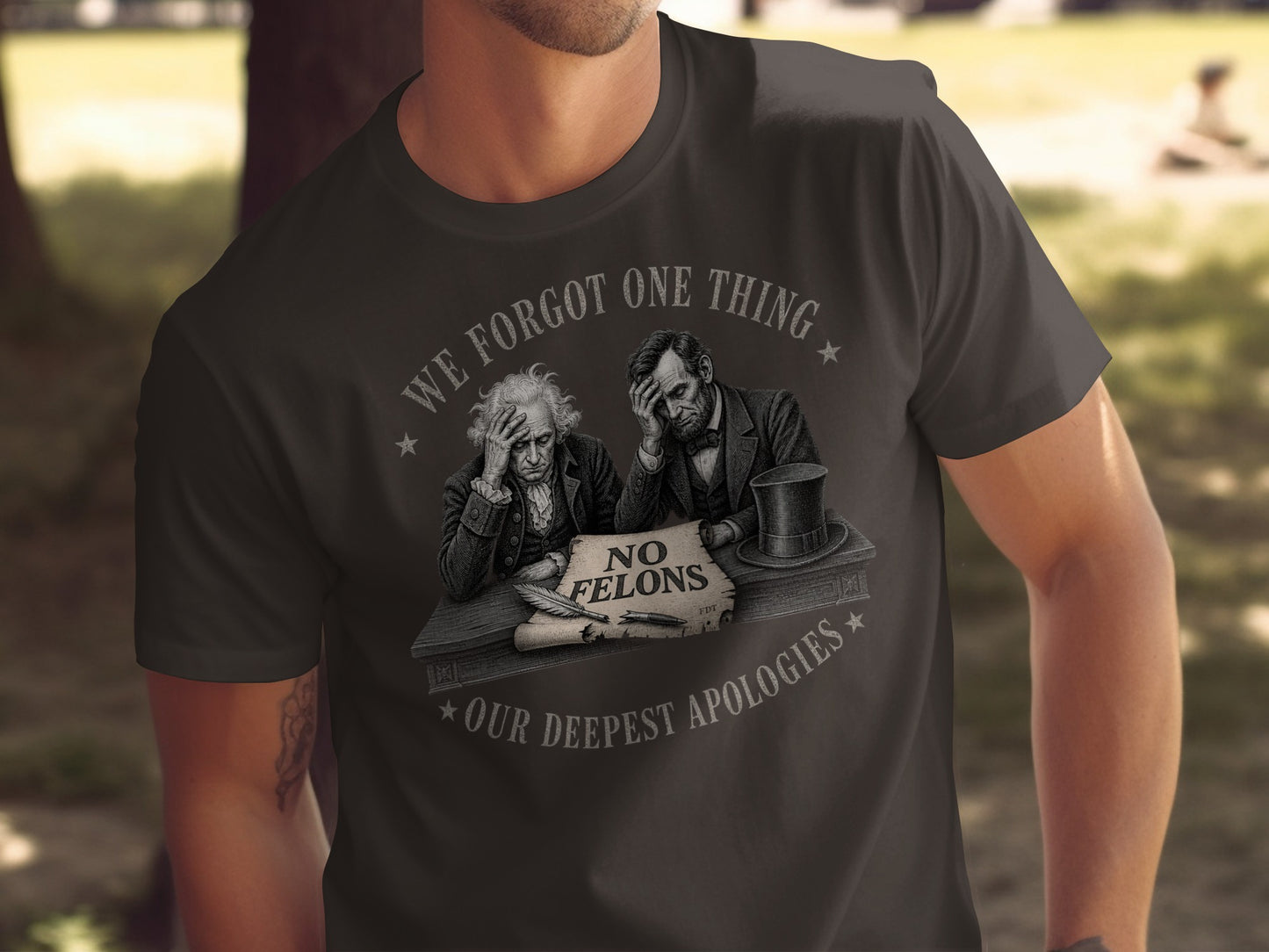 T-shirt with Lincoln and Washington figures, text "WE FORGOT ONE THING" and "NO FELONS OUR DEEPEST APOLOGIES".