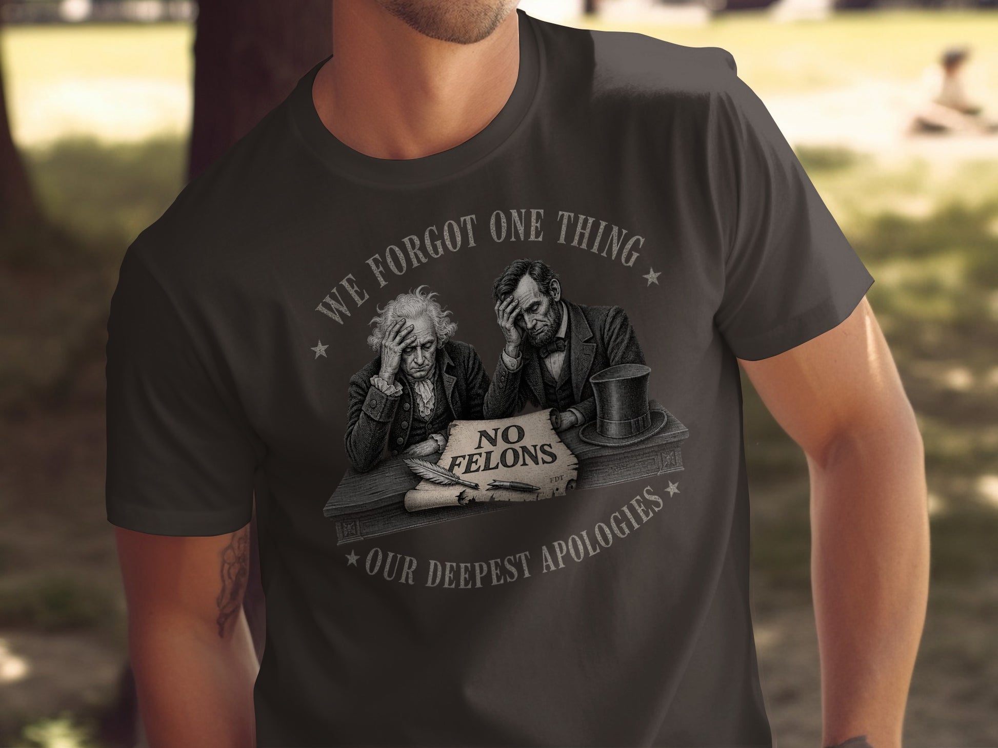 T-shirt with Lincoln and Washington figures, text "WE FORGOT ONE THING" and "NO FELONS OUR DEEPEST APOLOGIES".