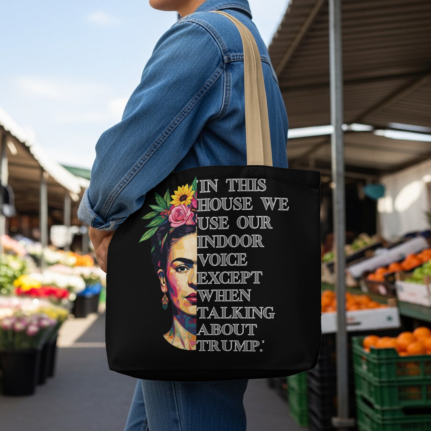 Black tote bag with Frida Kahlo portrait and text "In this house we use our indoor voice except when talking about Trump."