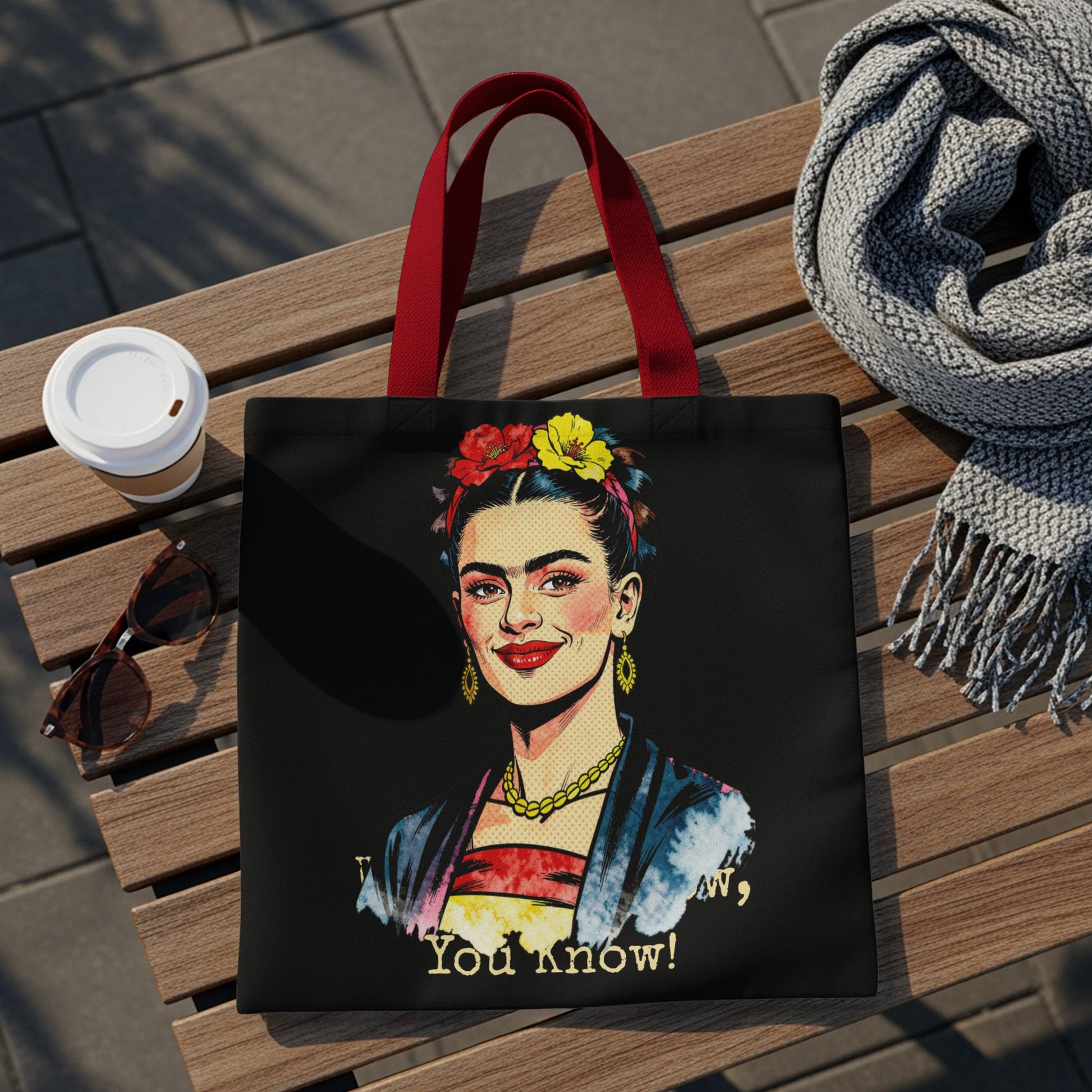 Frida Kahlo illustration on black tote bag with red handles and quote.