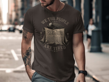 Brown t-shirt with "We the People are Tired" and eagle over document.
