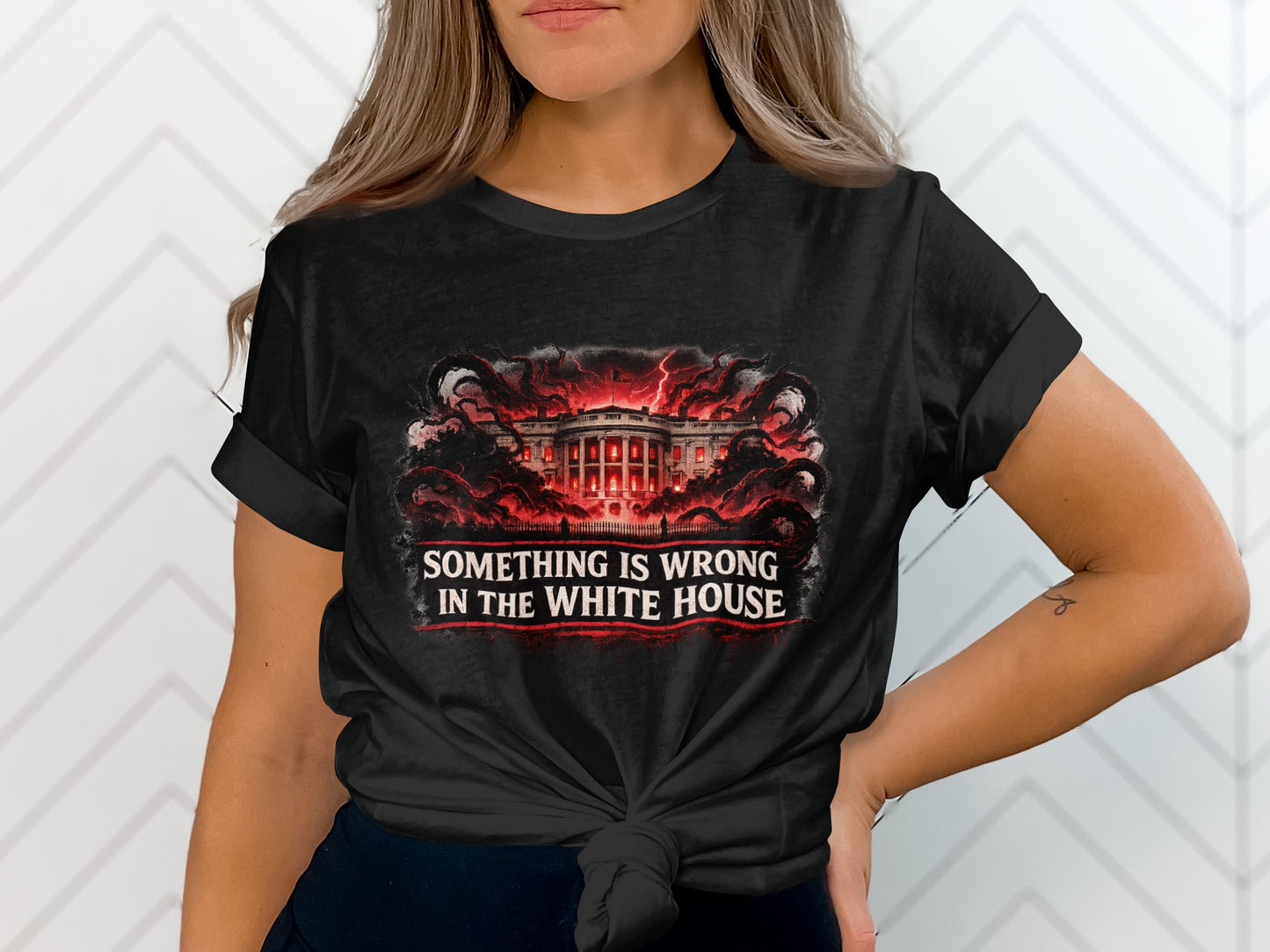 Black t-shirt with "SOMETHING IS WRONG IN THE WHITE HOUSE" text and fiery White House graphic.