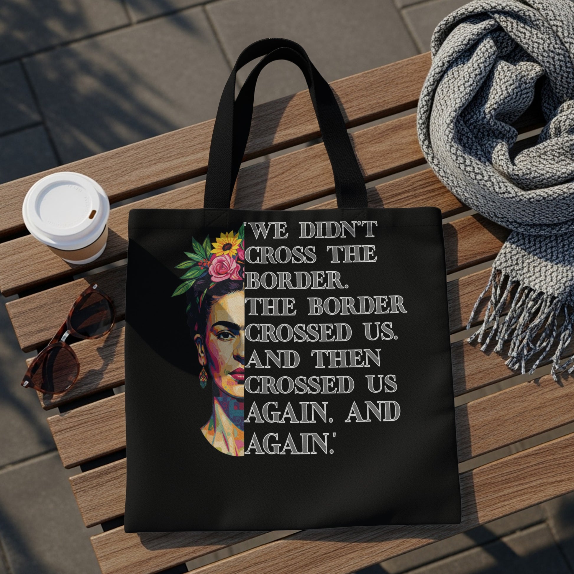 Black tote bag featuring Frida Kahlo portrait and quote about crossing borders.