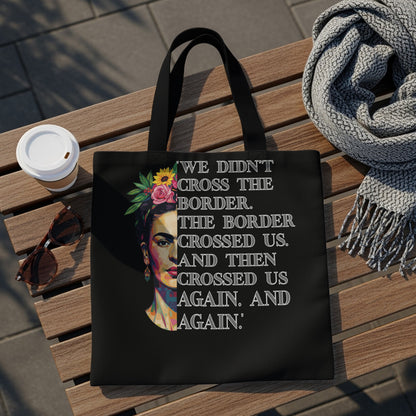 Black tote bag featuring Frida Kahlo portrait and quote about crossing borders.