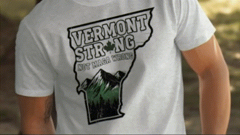 a person wearing a white t-shirt with a graphic design featuring a mountain range and the text "Vermont Strong" printed on it.