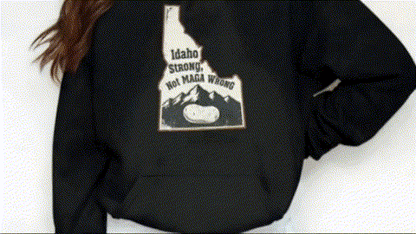 A person wearing a black hoodie with a graphic design on the back.