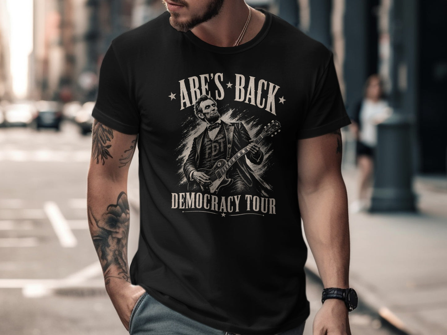 Black t-shirt with Abraham Lincoln playing guitar, "Abe's Back" and "Democracy Tour".