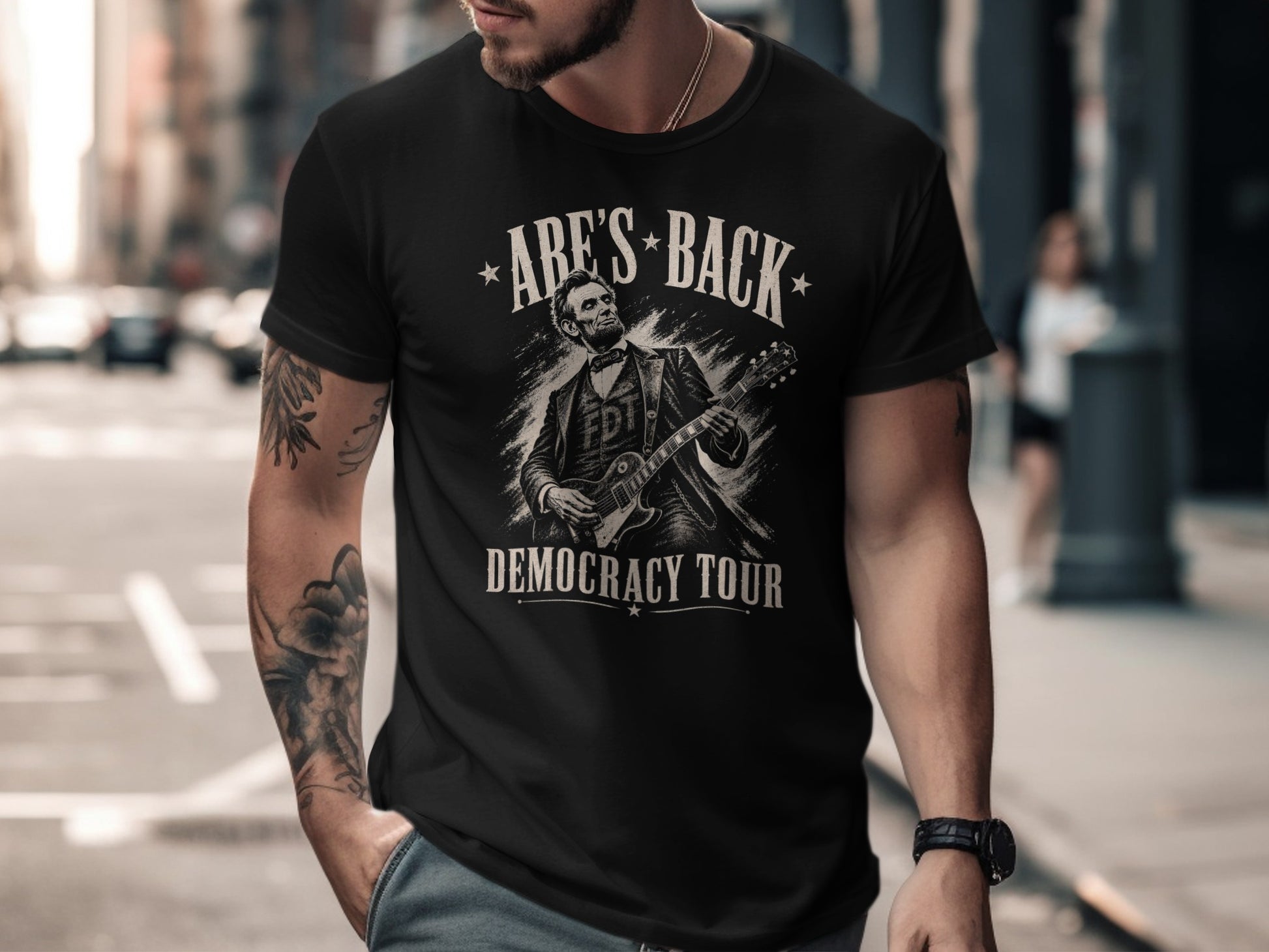 Black t-shirt with Abraham Lincoln playing guitar, "Abe's Back" and "Democracy Tour".