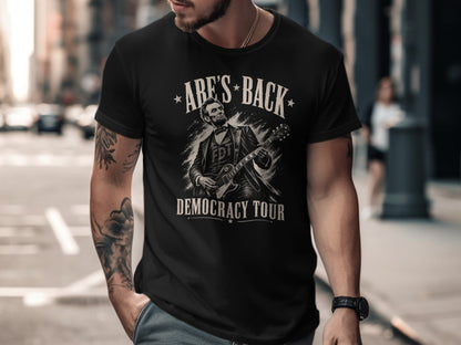Black t-shirt with Abraham Lincoln playing guitar, "Abe's Back" and "Democracy Tour".