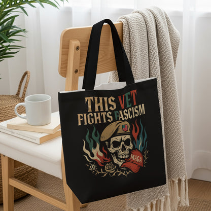 Black tote bag with a skull, flag, and "This Vet Fights Fascism" text.
