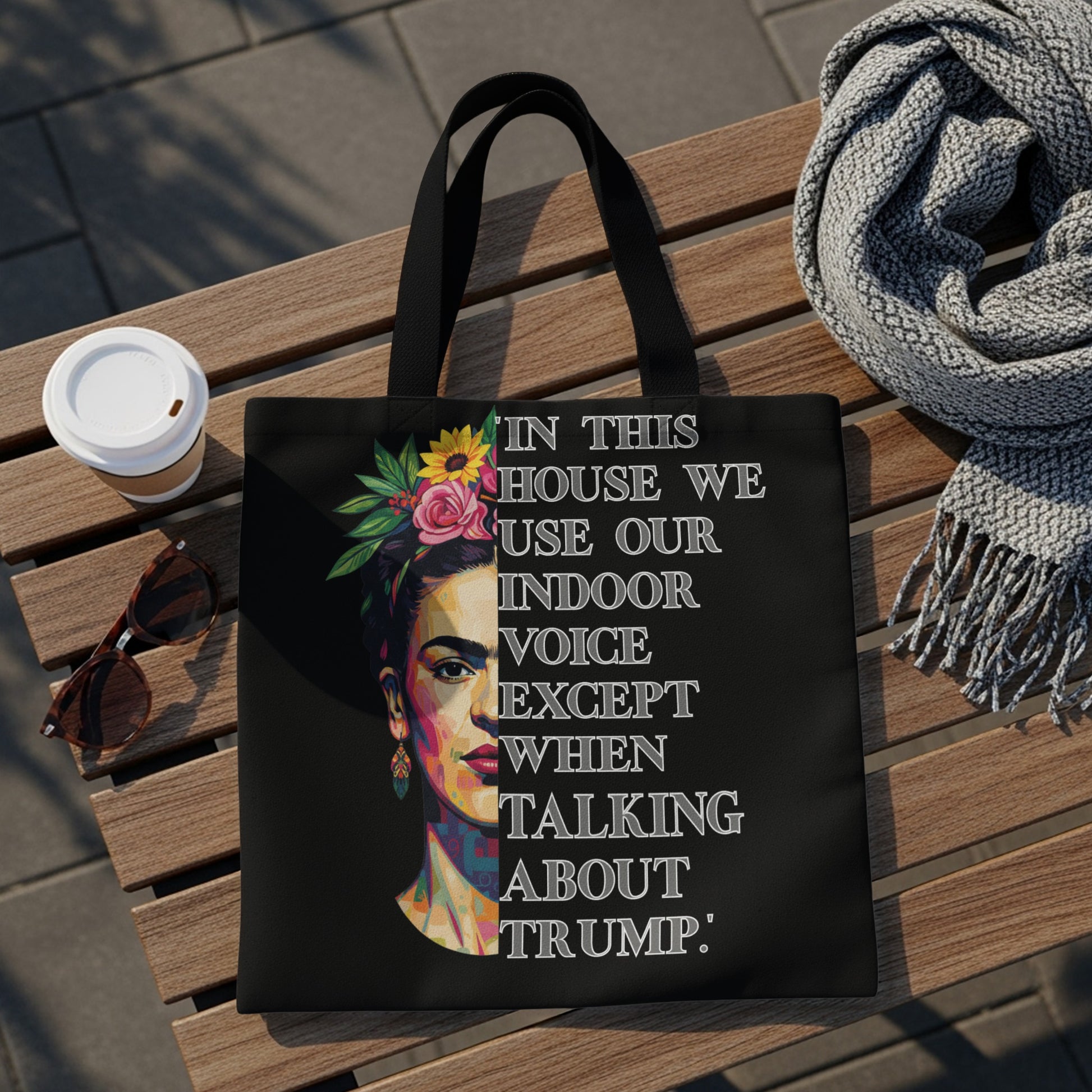 Black tote bag with Frida Kahlo portrait and text about using an indoor voice.