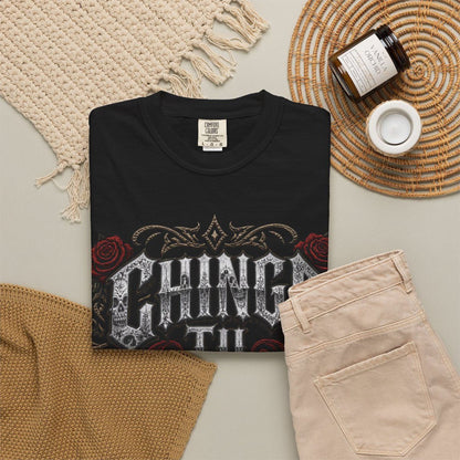 a black t-shirt with a graphic design, a pair of beige pants, a woven basket, a candle, and a label.