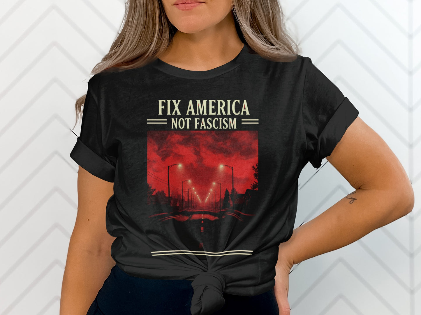 Black t-shirt with text "FIX AMERICA NOT FASCISM" and street scene.