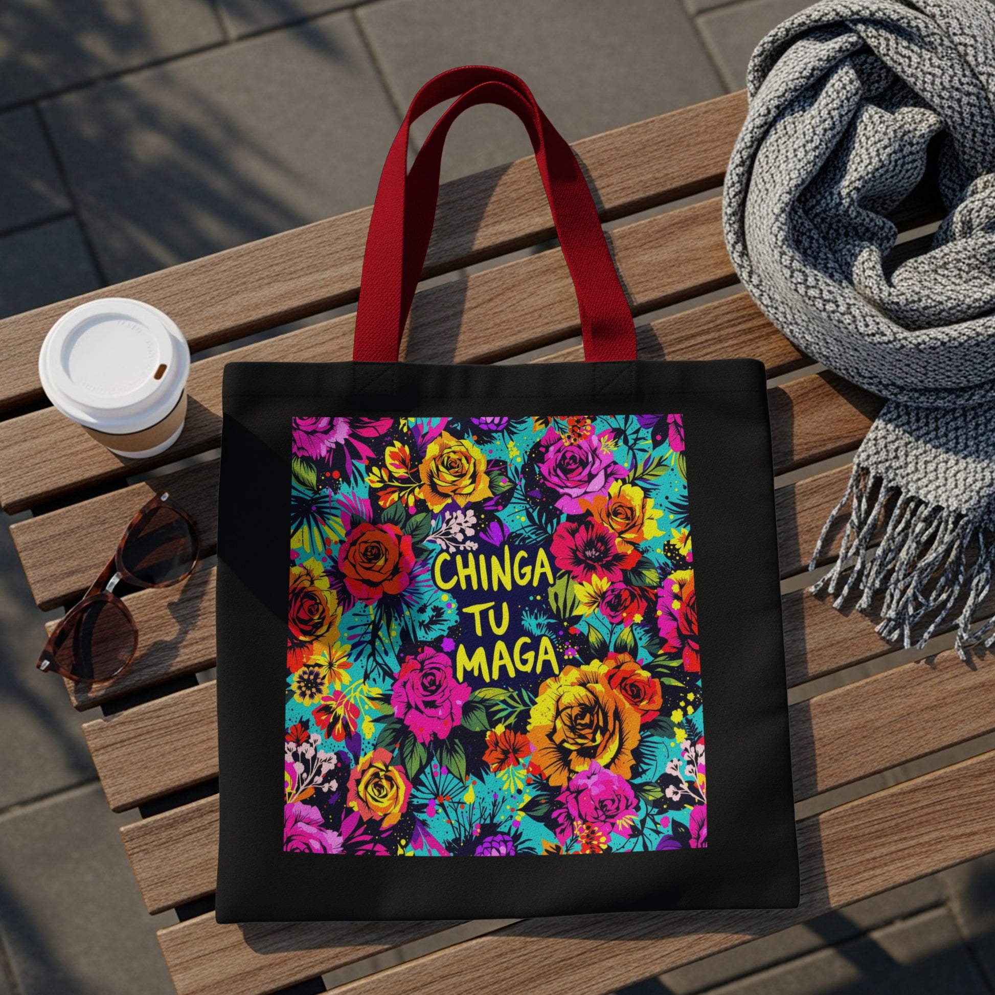 Black tote bag with vibrant floral print and "Chinga Tu Maga" text.