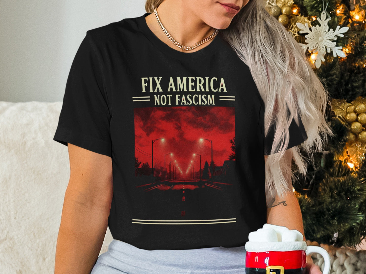 Black t-shirt with "FIX AMERICA NOT FASCISM" text and fiery red cityscape.