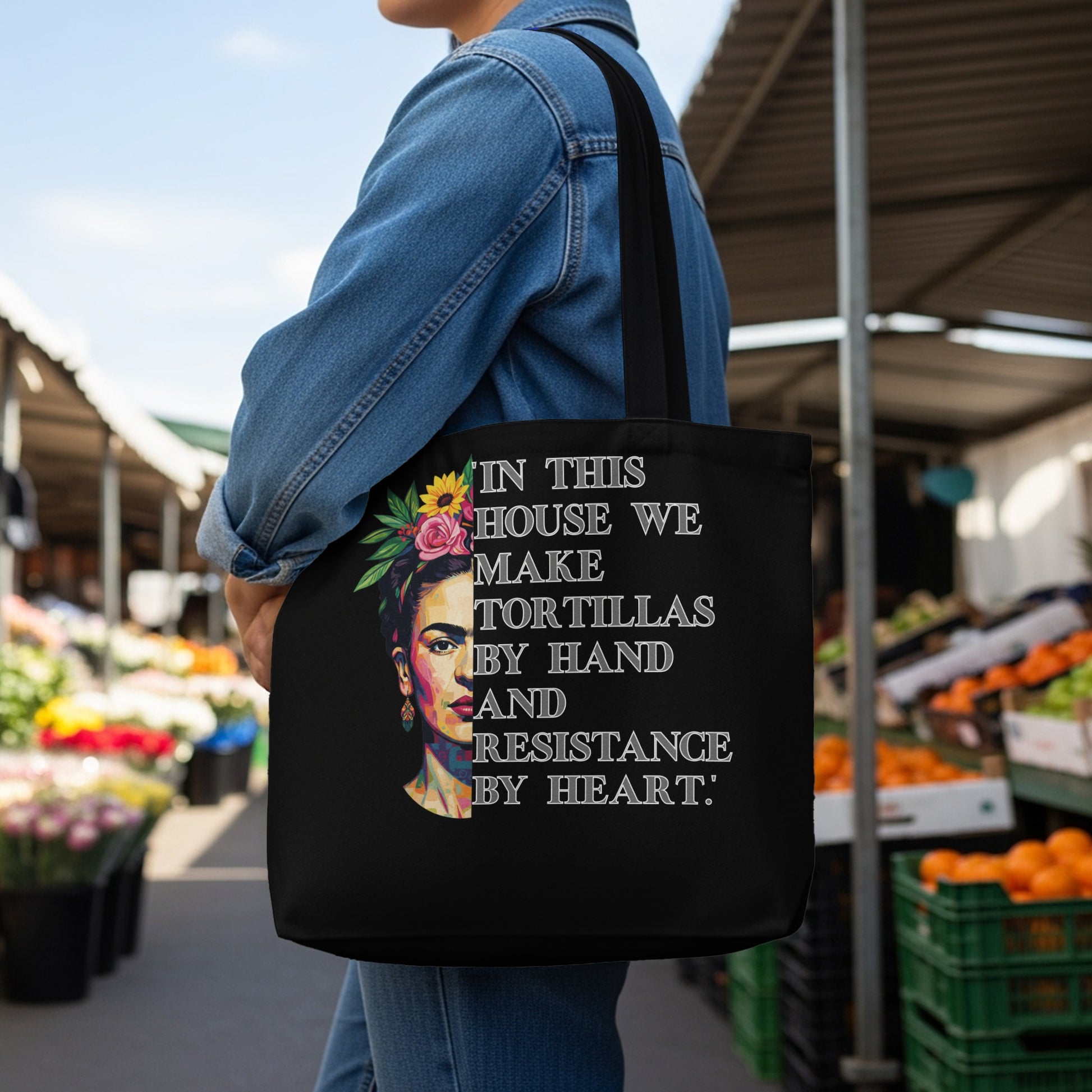 Tote bag with Frida Kahlo portrait and "In this house we make tortillas by hand and resistance by heart" text.