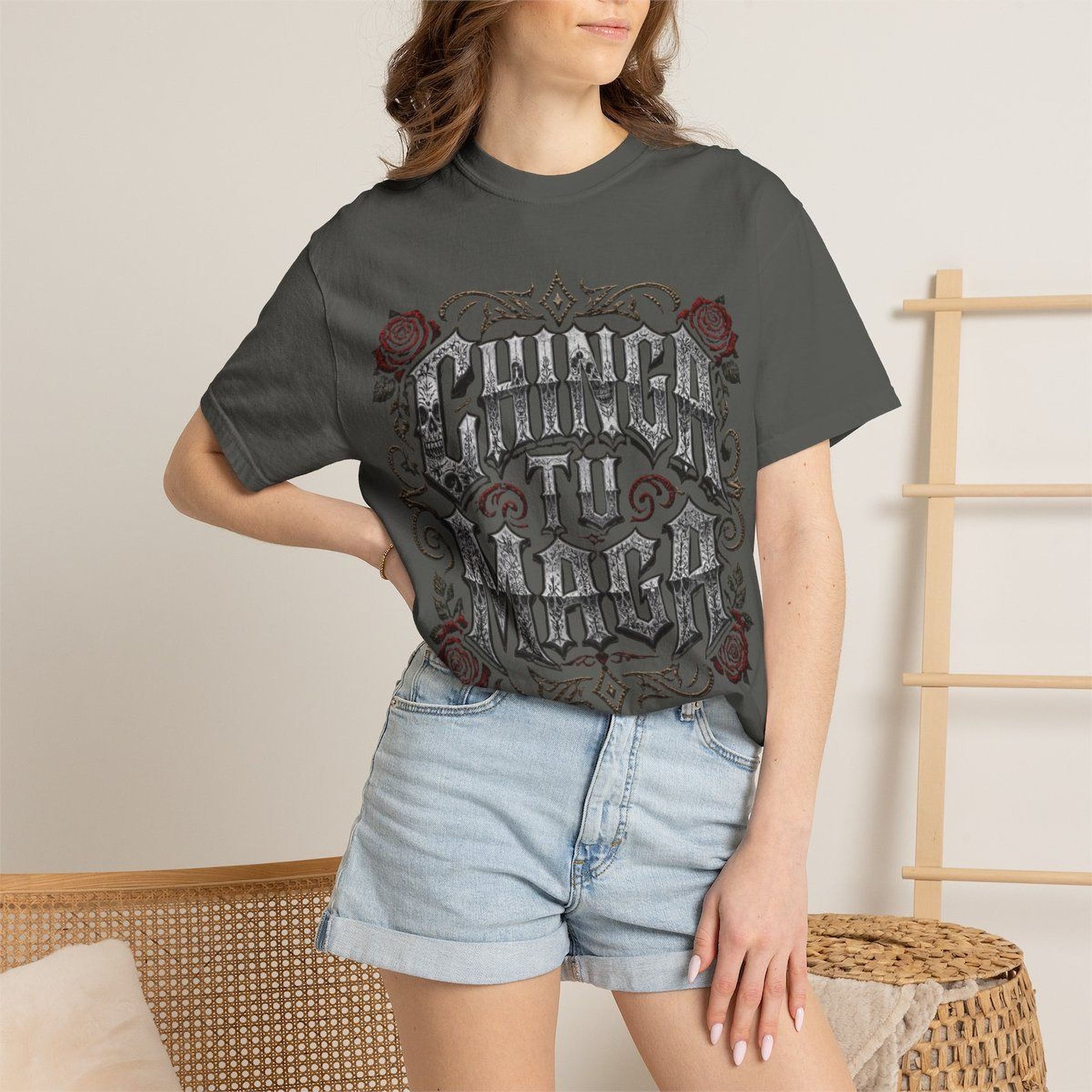 A woman wearing a gray t-shirt with a graphic design and denim shorts stands in front of a wooden ladder.