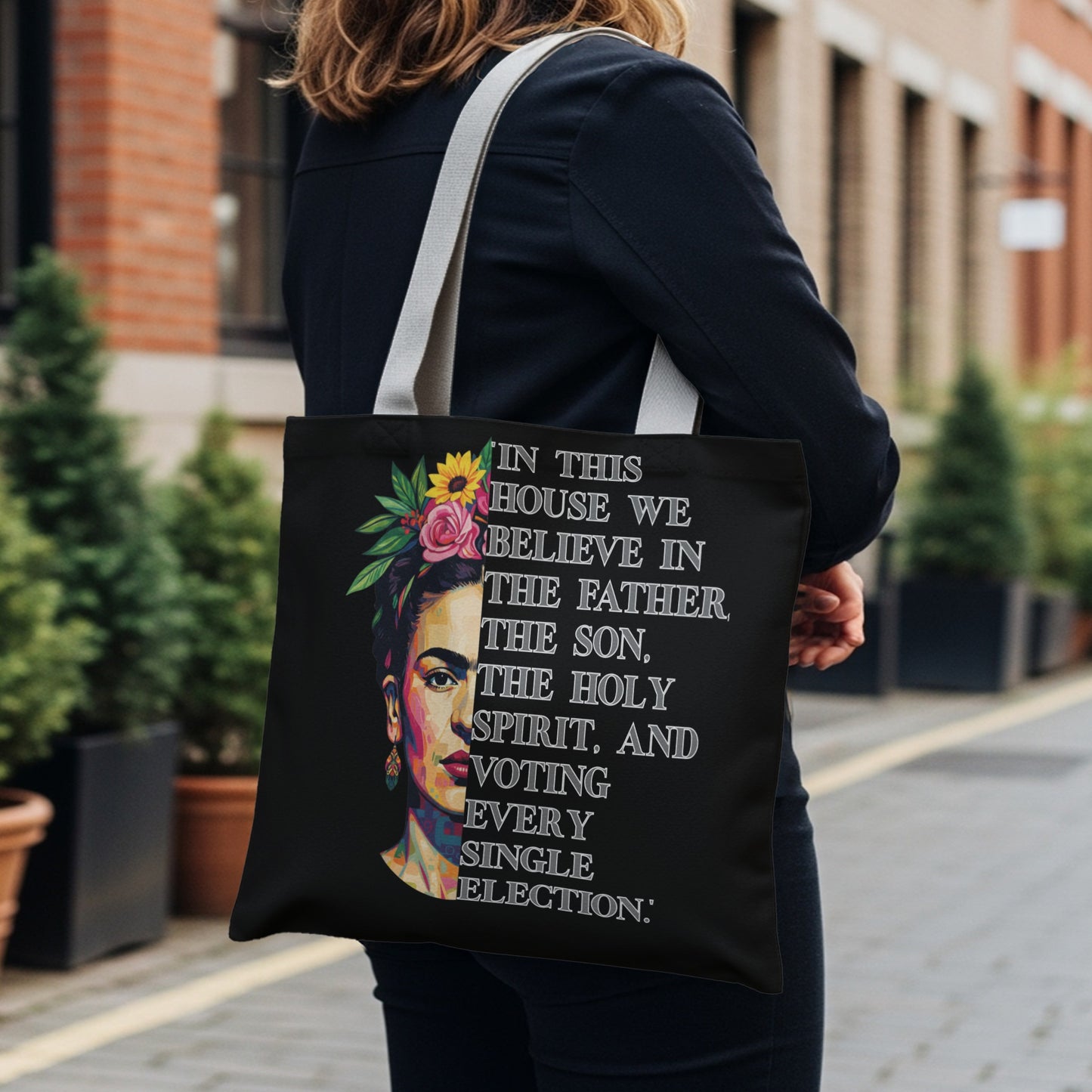 Black tote bag with Frida Kahlo portrait and text about voting.