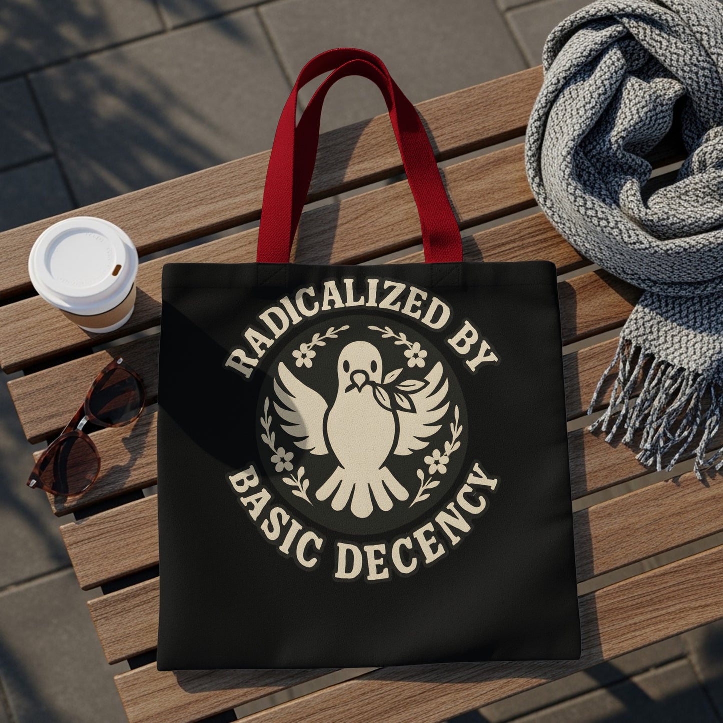 Black tote bag with "Radicalized by Basic Decency" text and dove emblem.