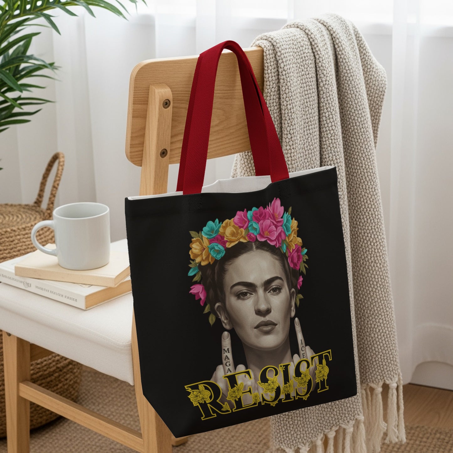 Frida Kahlo portrait with floral crown and "RESIST" text on a black tote bag.