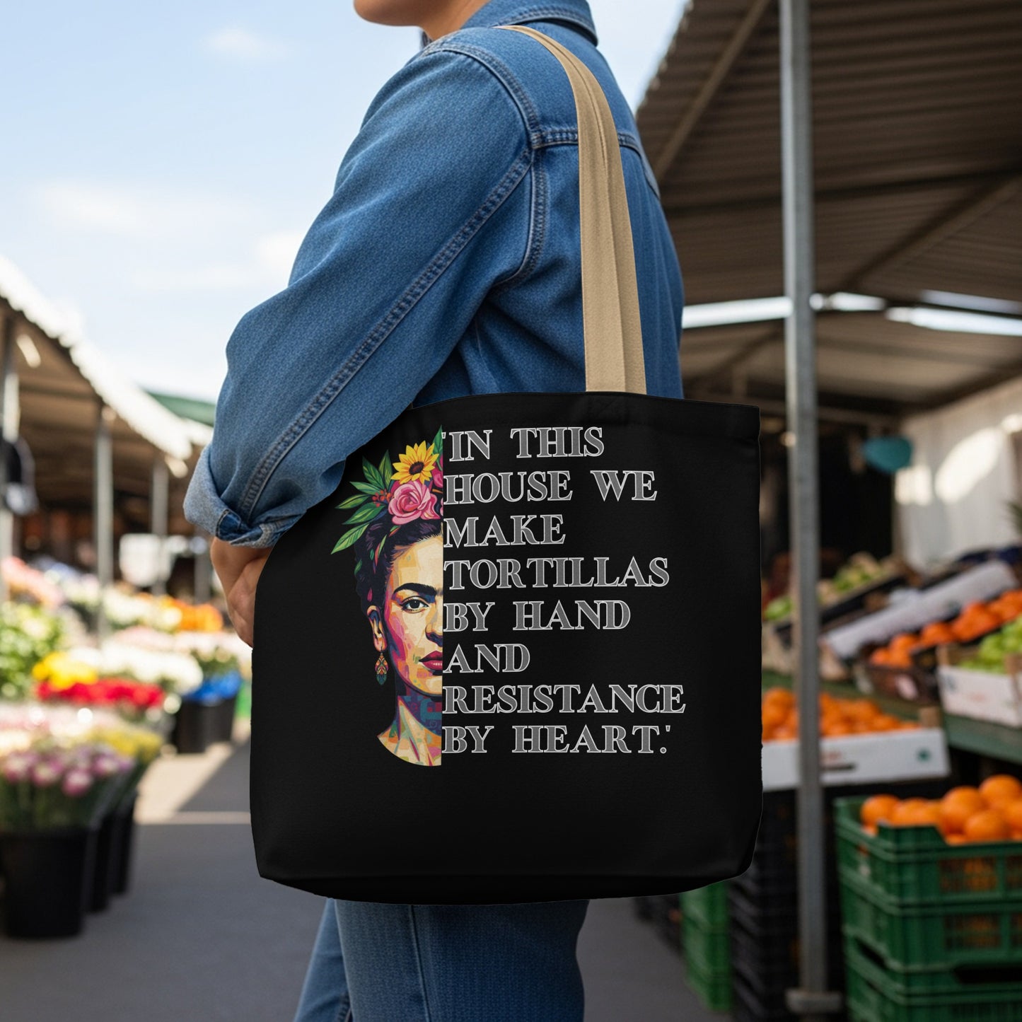 Black tote bag with Frida Kahlo portrait and quote "In this house we make tortillas by hand and resistance by heart."