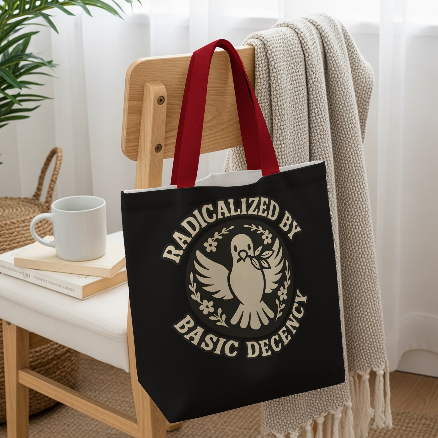 Black tote bag with "Radicalized by Basic Decency" slogan and dove emblem.