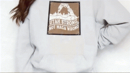 A person wearing a white sweatshirt with a graphic design on the back.