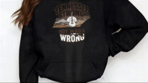 A person wearing a black sweatshirt with a graphic design on it.