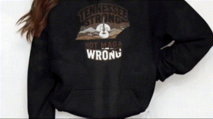 A person wearing a black sweatshirt with a graphic design on it.