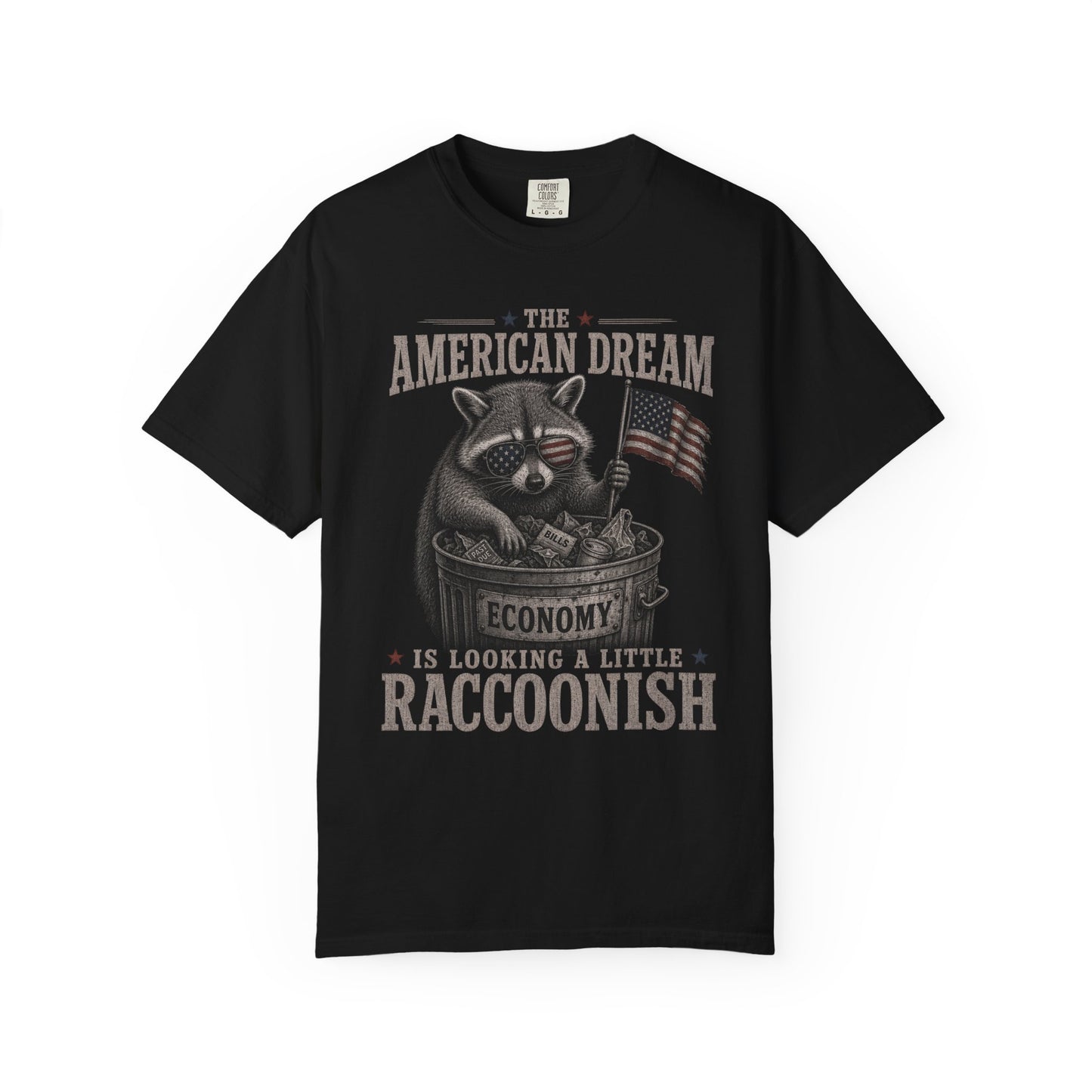 T-shirt with raccoon wearing sunglasses, holding American flag and money, text reads "The American Dream Economy is Looking a Little Raccoonish".