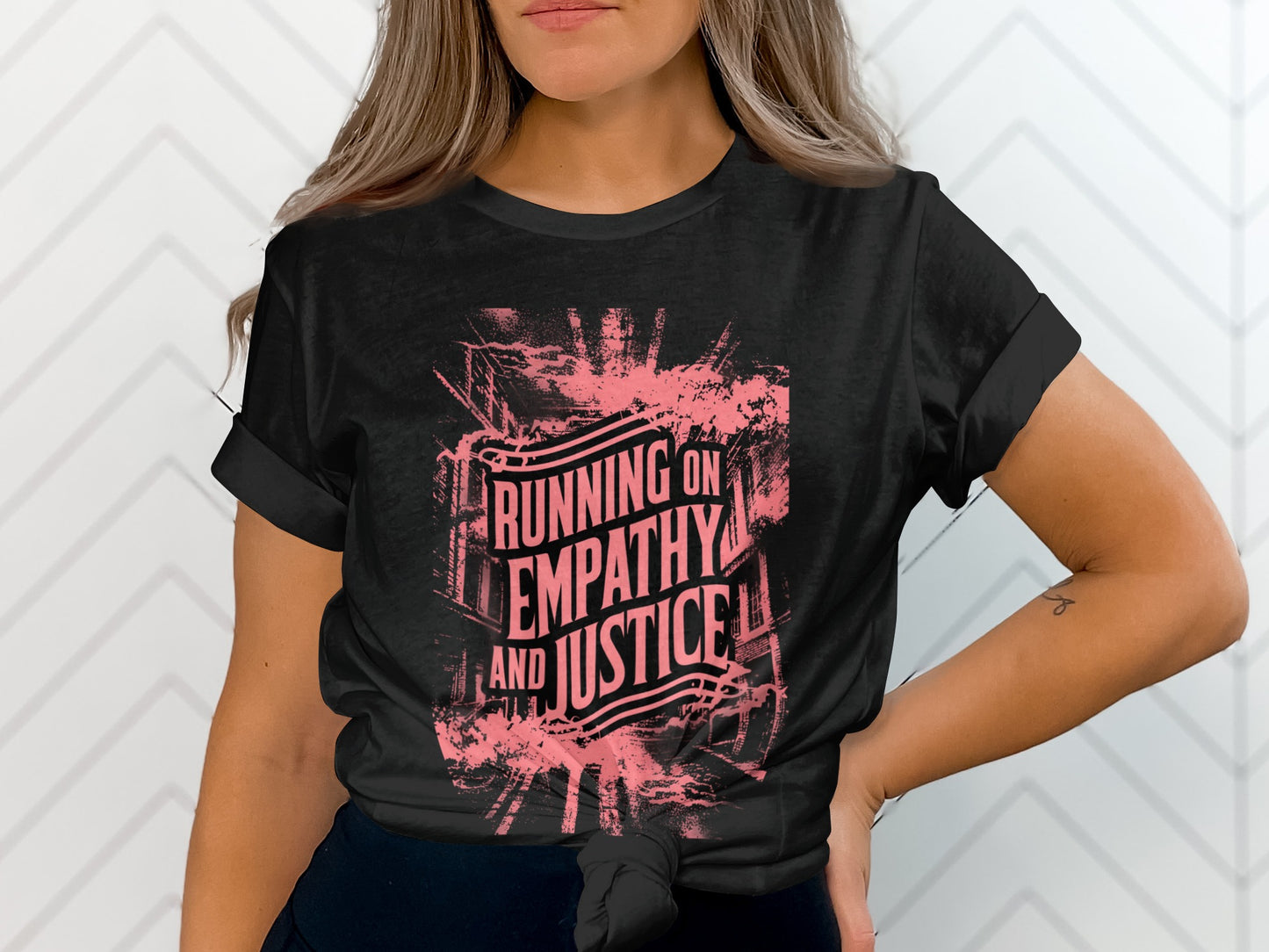 Black t-shirt with "Running on Empathy and Justice" text in pink distressed font.