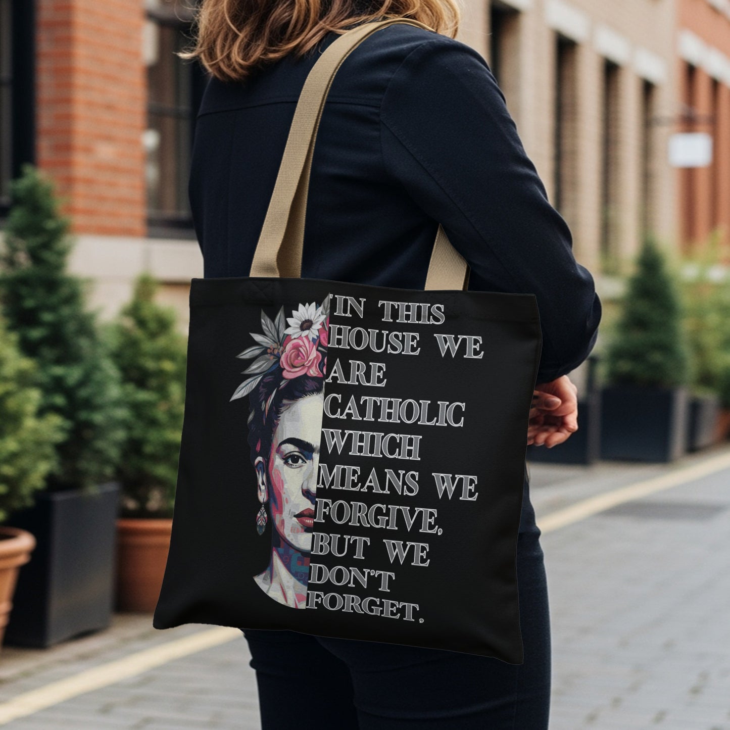 Tote bag featuring Frida Kahlo portrait with quote: "In this house we are Catholic which means we forgive, but we don't forget."