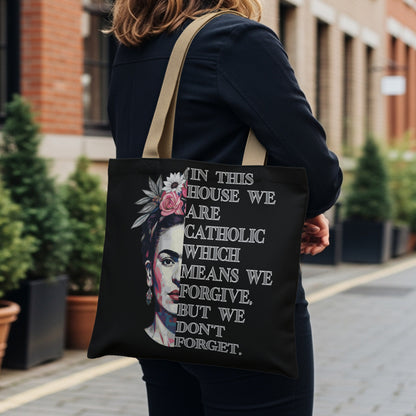 Tote bag featuring Frida Kahlo portrait with quote: "In this house we are Catholic which means we forgive, but we don't forget."