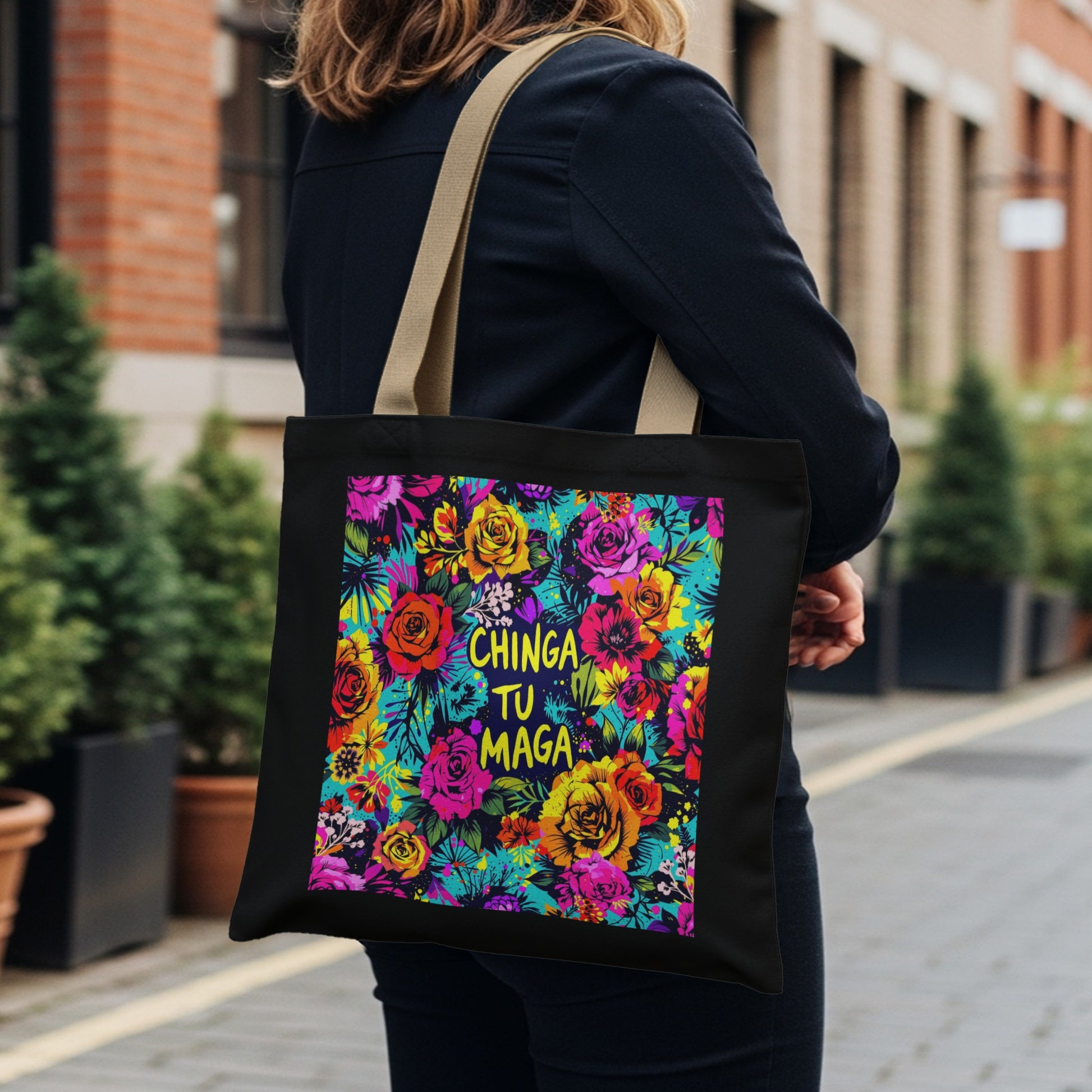 Black tote bag with vibrant floral print and "Chinga Tu Maga" text.